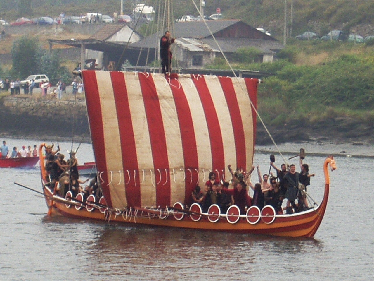 Réplica de barco vikingo desembarcando al pie de las Torres do Oeste en la Romería Vikinga de Catoira