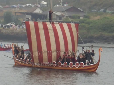 Barco vikingo llegando a la orilla en la Romería Vikinga de Catoira
