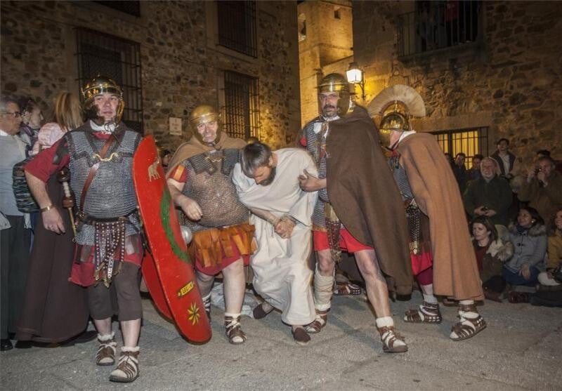 Soldados romanos conducen a Jesús por una calle de piedra durante la Pasión Viviente de Cáceres