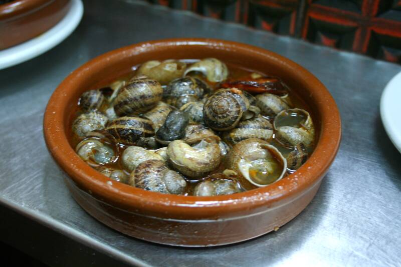 Cazuela de barro con caracoles a la madrileña en su salsa, tapa de tasca en el Rastro.