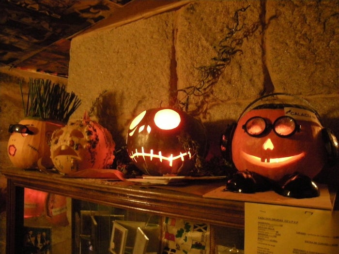 Calabazas talladas con caras iluminadas por dentro en una noche de Samaín
