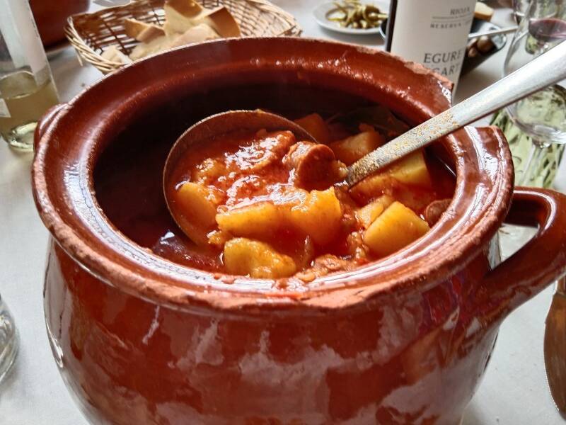 Cazuela de barro con patatas a la riojana, chorizo y su caldo rojo de pimentón