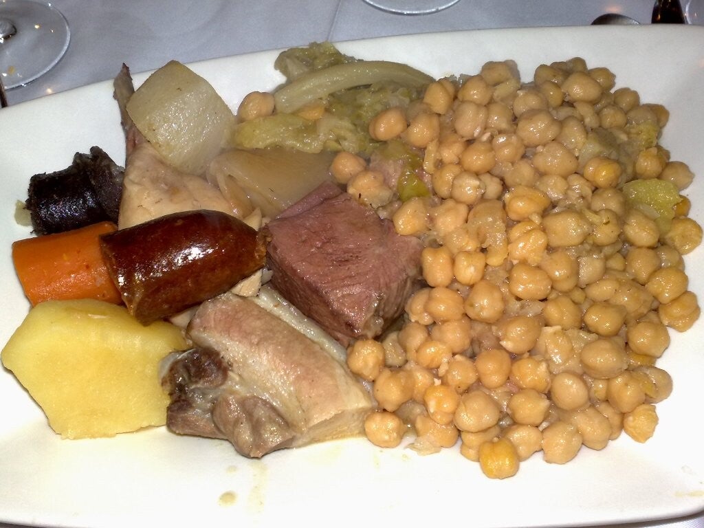 Fuente de cocido madrileño con garbanzos, chorizo, morcillo y verduras, el gran guiso de Madrid.
