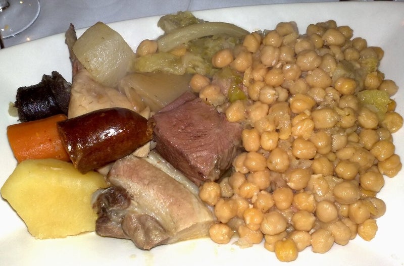 Fuente de cocido madrileño con garbanzos, chorizo, morcillo y verduras, el gran guiso de Madrid.