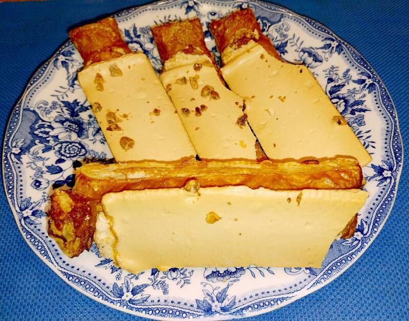 Corbatas de Unquera en un plato de loza: hojaldre en forma de lazo con glaseado y almendra