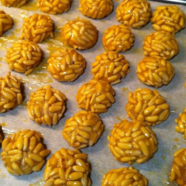 Parte del proceso de elaboración de panellets de piñones dorados al horno, los dulces de mazapán de almendra de la Castanyada catalana, listos para hornear