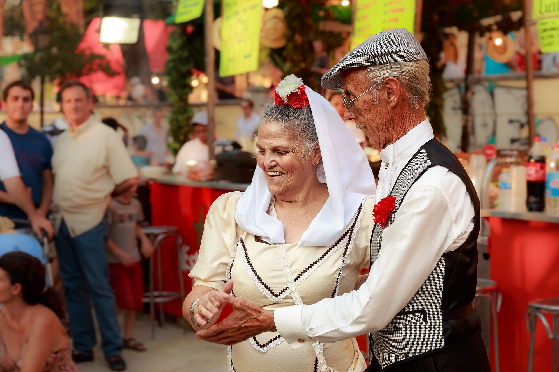 Pareja bailando chotis vestidos de chulapos en las Fiestas de la Paloma, Madrid
