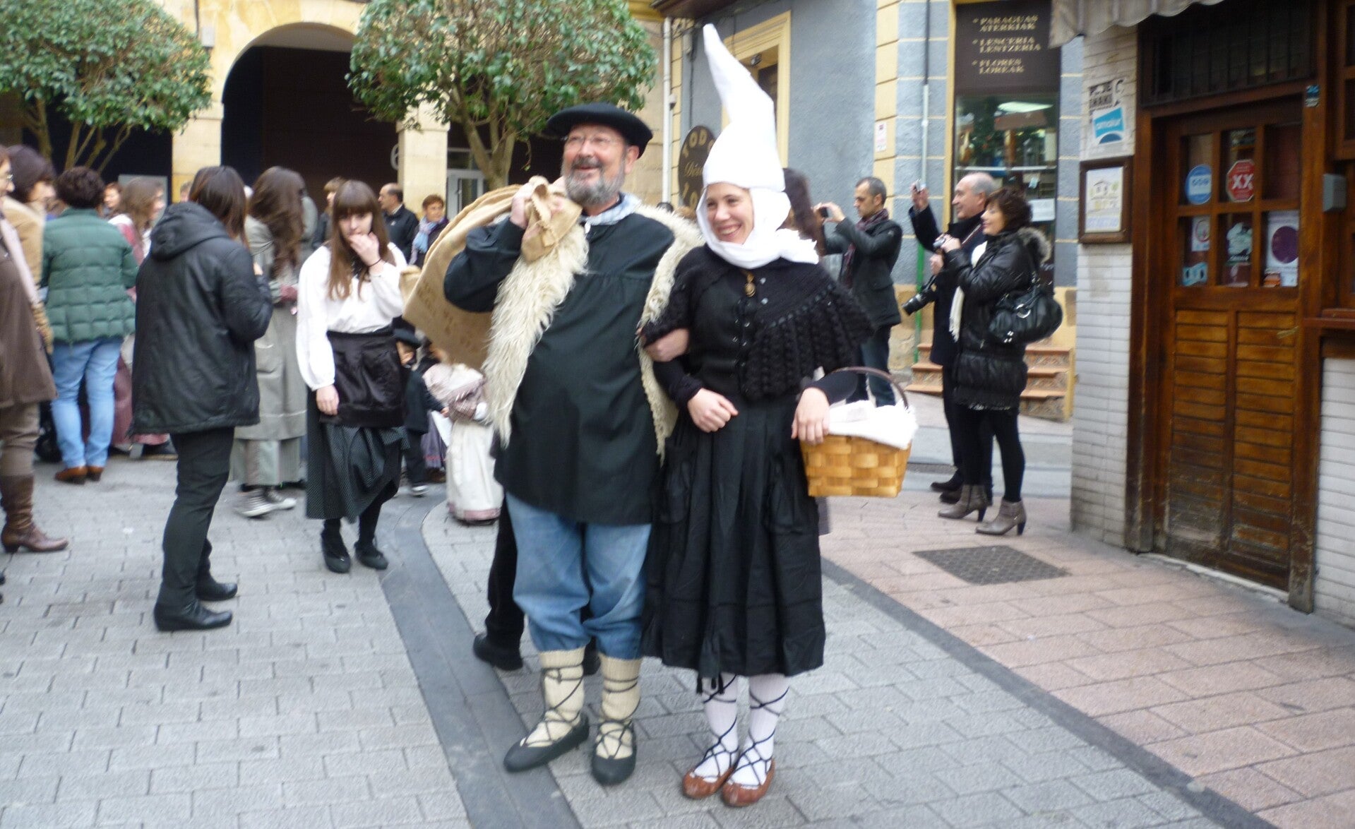 El Olentzero y Mari Domingi desfilando por la calle rodeados de gente