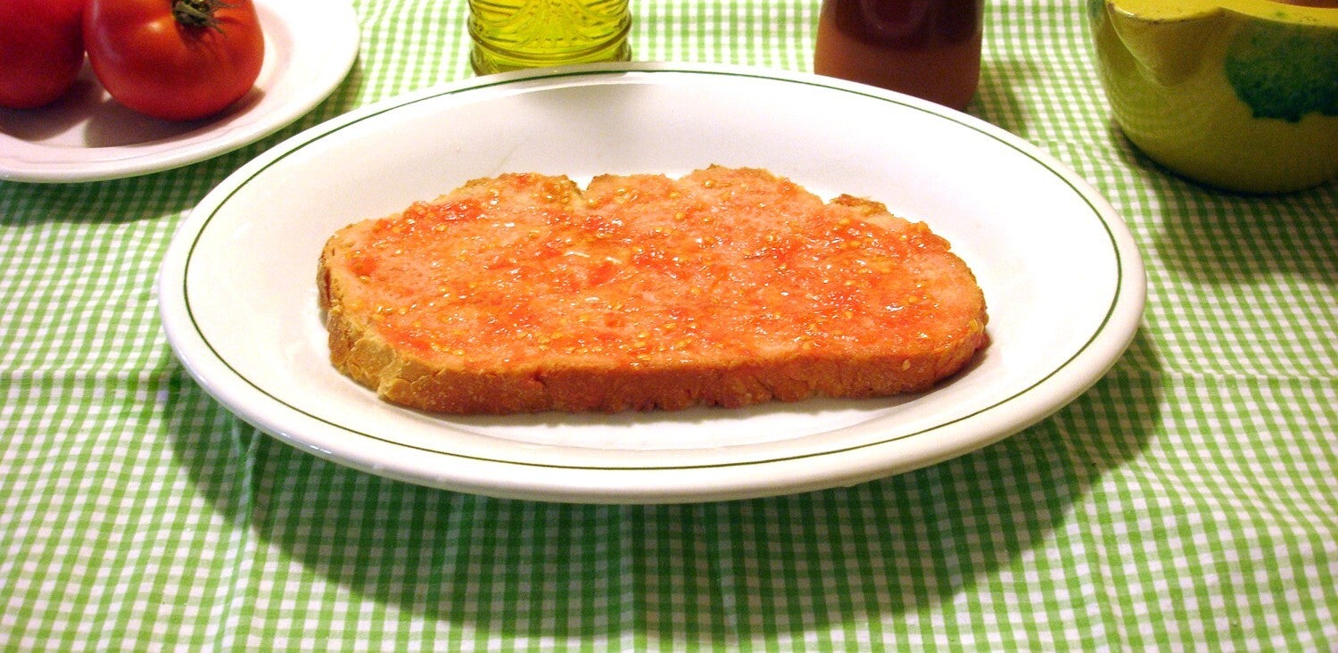 Rebanada de pan tostado untada con tomate y aceite, el pa amb tomàquet catalán