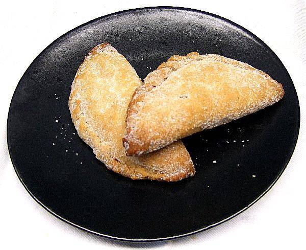 Pastissets, empanadillas dulces rellenas de boniato y espolvoreadas de azúcar.