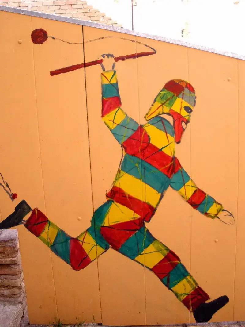 Mural del Cipotegato de Tarazona, con el traje de rombos amarillos, rojos y verdes y la vara con la bola