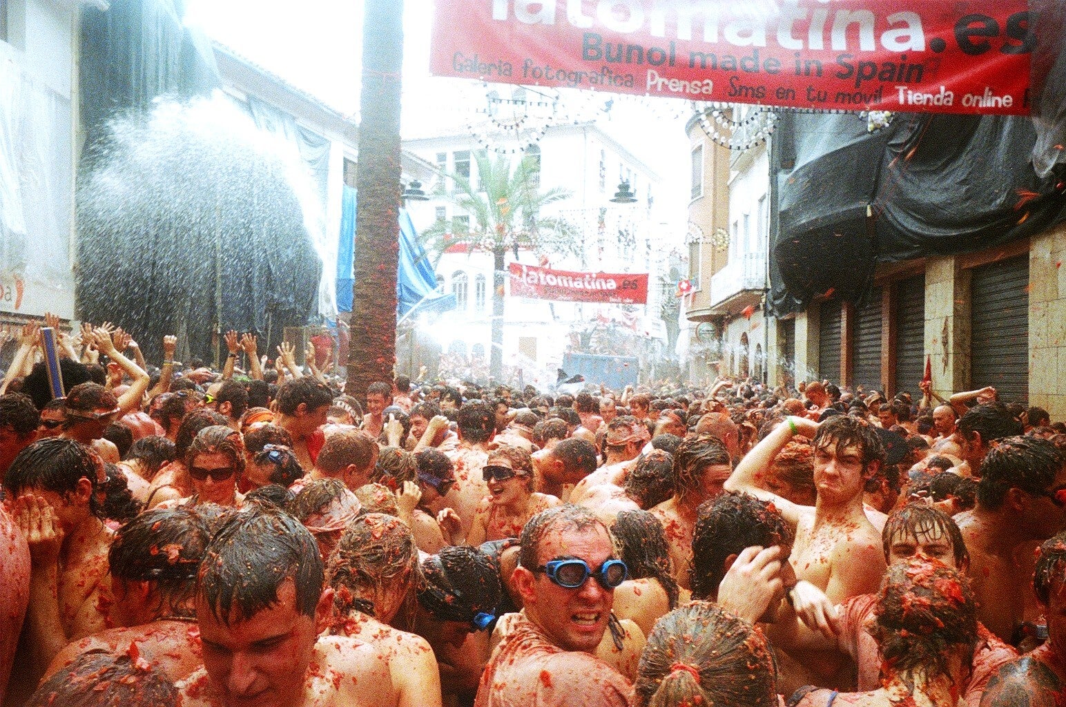 Multitud cubierta de tomate durante la batalla de La Tomatina, en Buñol