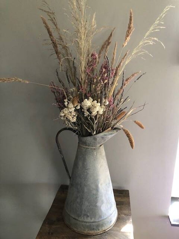 Droogbloemen in oude zinken kan.