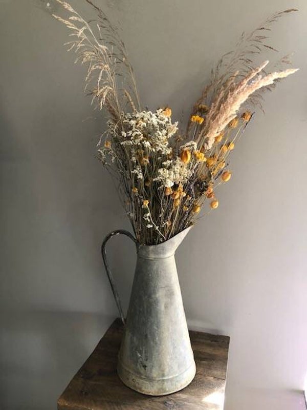 Droogbloemen in oude zinken kan.