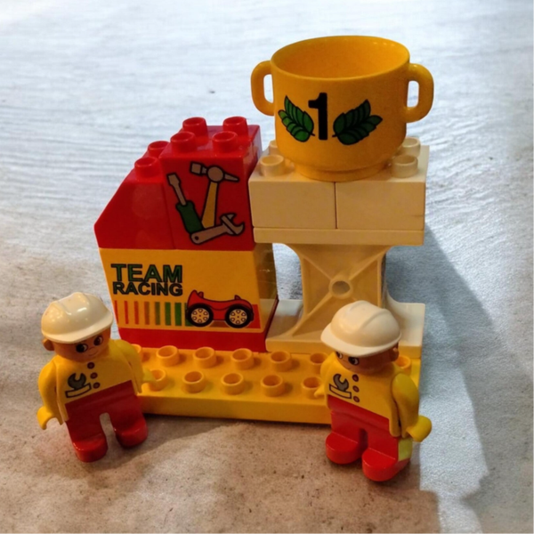 LEGO Duplo Vintage-Konvolut aus 3085 Team Racing (2001) – Boxengasse & Siegerpodest mit Pokal