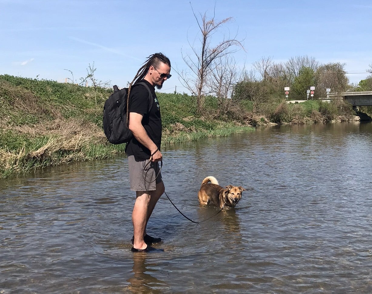 Georg - Hundetrainer in Baden, steht mit seinem Hund Gimli im Fluss