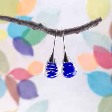 Trompet oorbellen met transparante glasbolletjes met een blauwe spiraal
