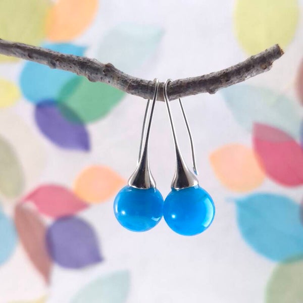 Trompet oorbellen met turquoiseblauwe glasbolletjes met wolk-effect