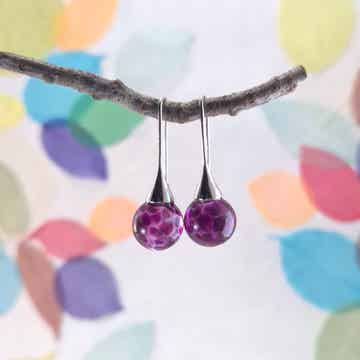 Trompet oorbellen met transparante glasbolletjes met donkerroze vlekpatroon