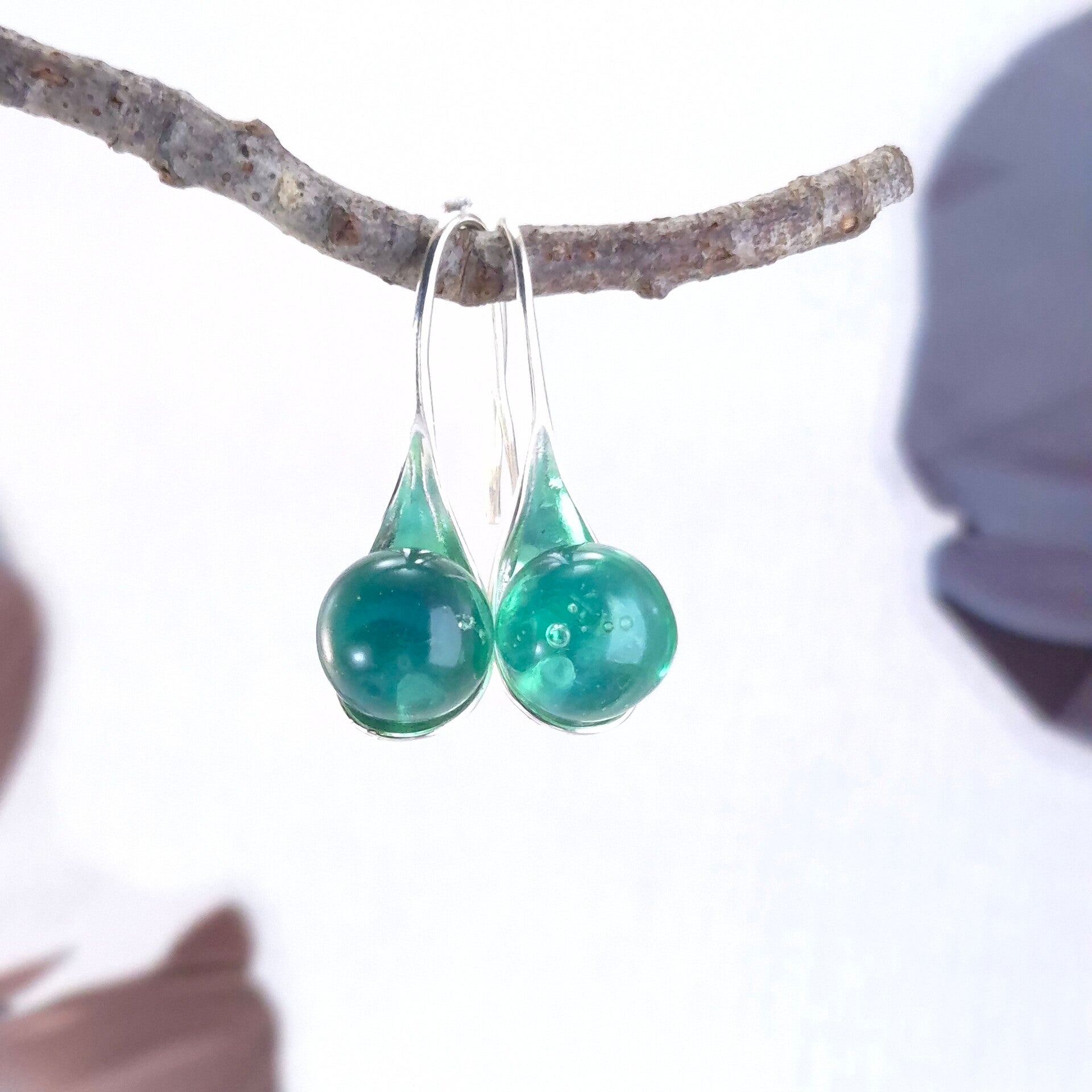 Verzilverde oorbellen met zachtgroene glasbolletjes