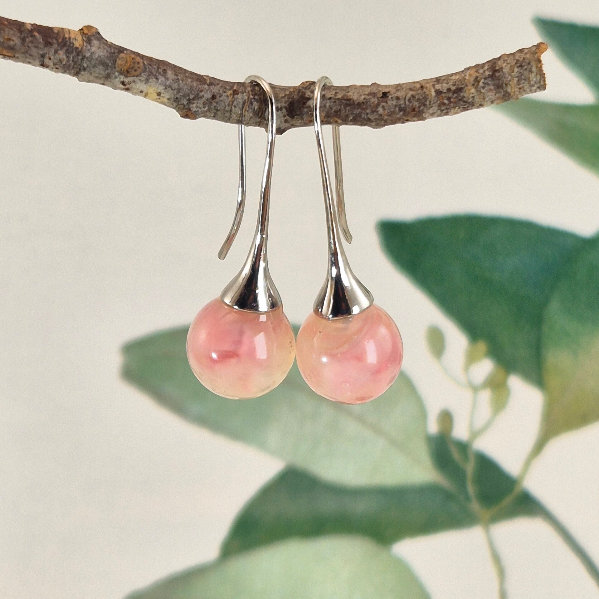 Trompetvormige glazen oorbellen met bolletjes van zacht roze glas met pearl-effect