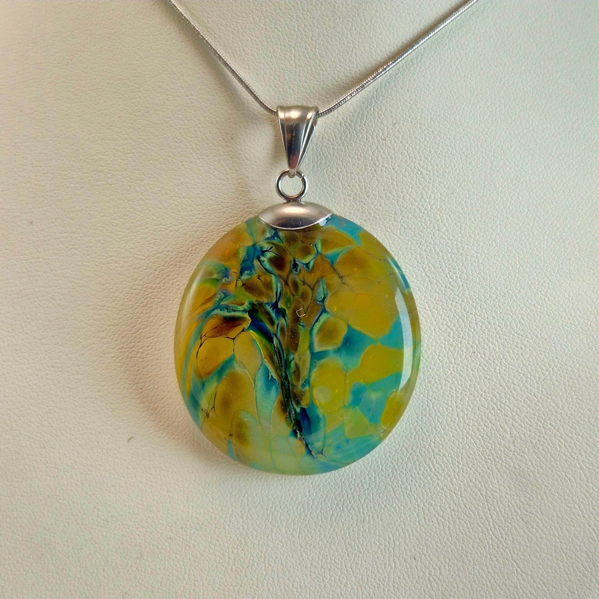 Semi transparante glazen hanger met vlekpatroon mosterdgeel en turquoise