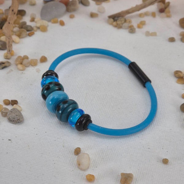 Armband met 7 glaskralen van turquoise en zwart glas