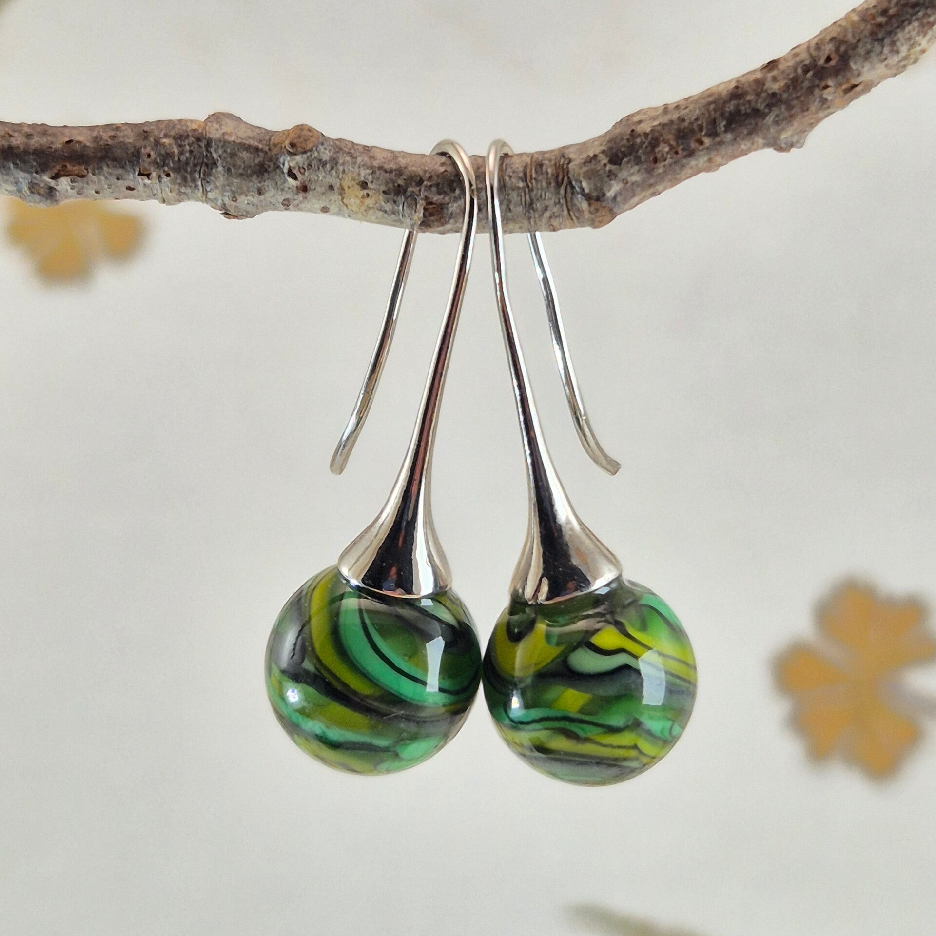 Trompet oorbellen met bolletjes van groen/geel/zwart glas met streeppatroon