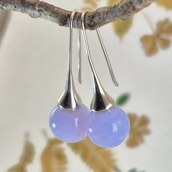 Trompet oorbellen met bolletjes van licht paars/blauw glas