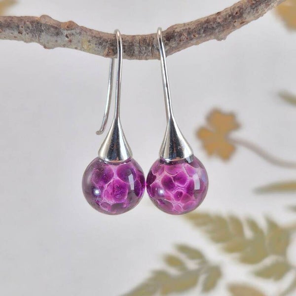 Trompet oorbellen met bolletjes van transparant glas met paars stippatroon