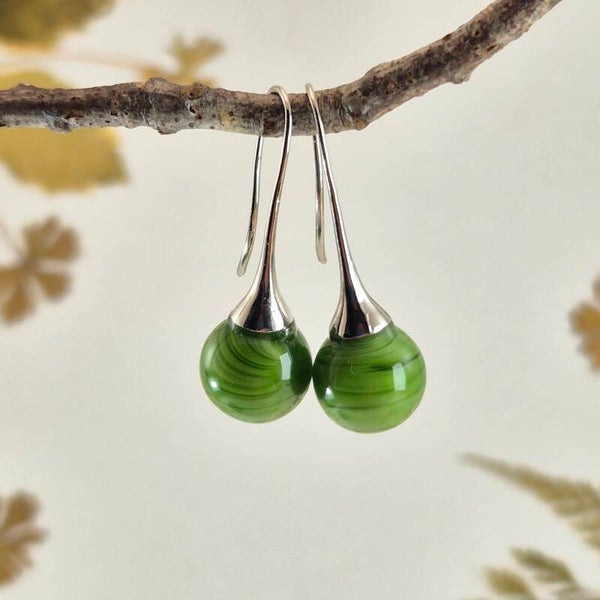 Trompet oorbellen met groene glasbolletjes met streeppatroon en parelglans