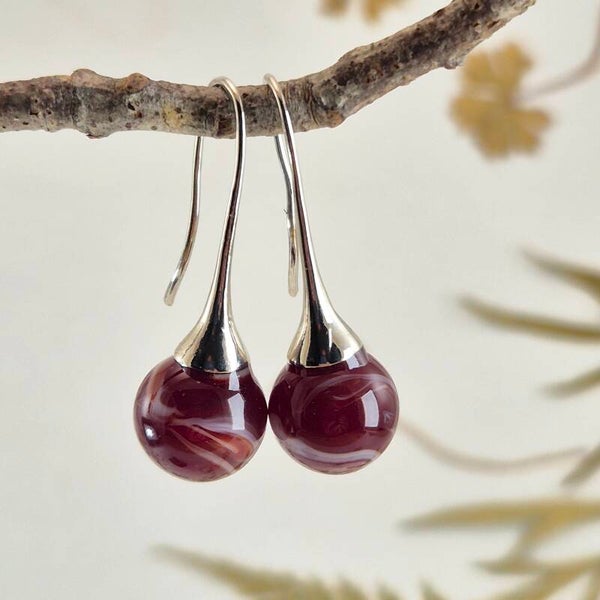 Trompet oorbellen met bolletjes van donkerrood met wit glas
