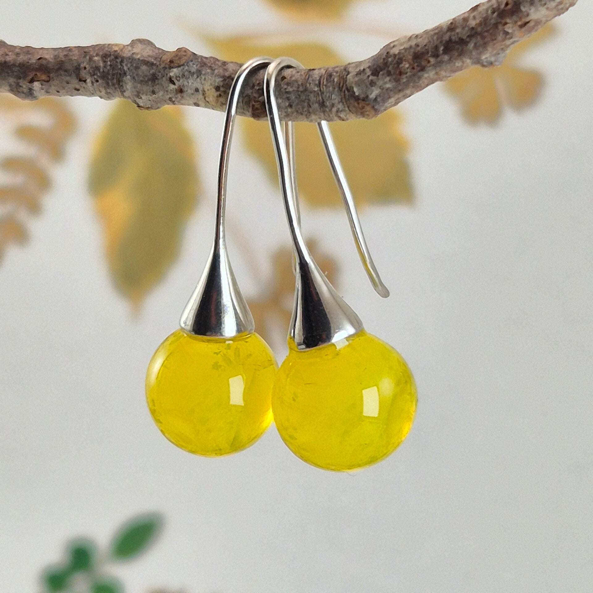 Trompet oorbellen met bolletjes van semi-transparant geel glas met wolk-effect