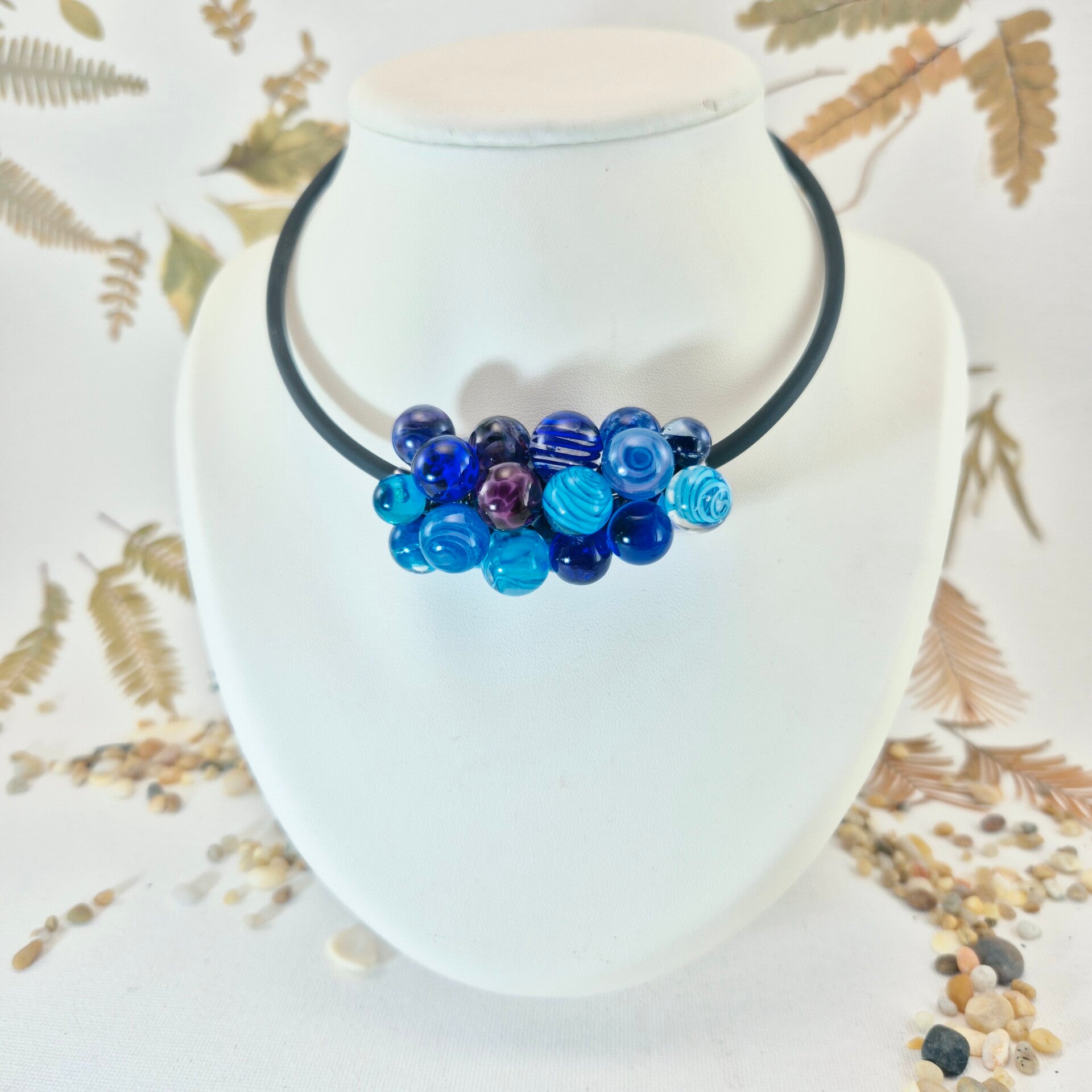 Collier/halsketting met een trosje glasbolletjes in blauw- en lia/paars tinten