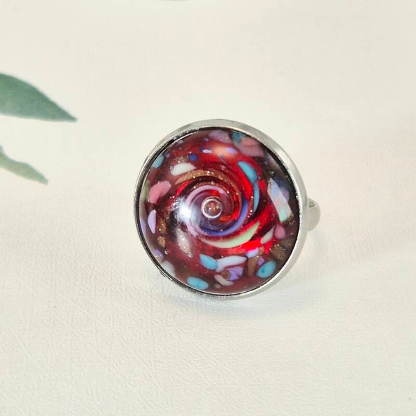 Verstelbare ring met ingezette glastop - transparant rood glas met pastelkleurtjes, goud-sparkeling  en een luchtbelletje