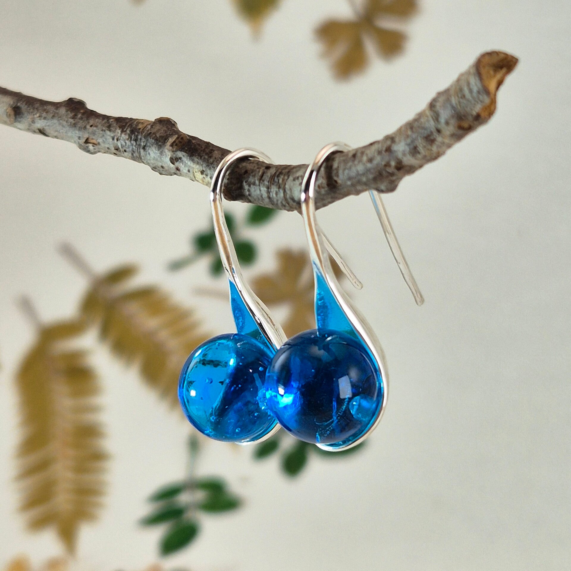 Verzilverde oorbellen met transparant turquoise glasbolletjes