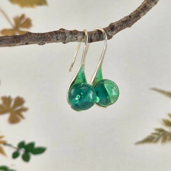 Verzilverde oorbellen met zachtgroene glasbolletjes