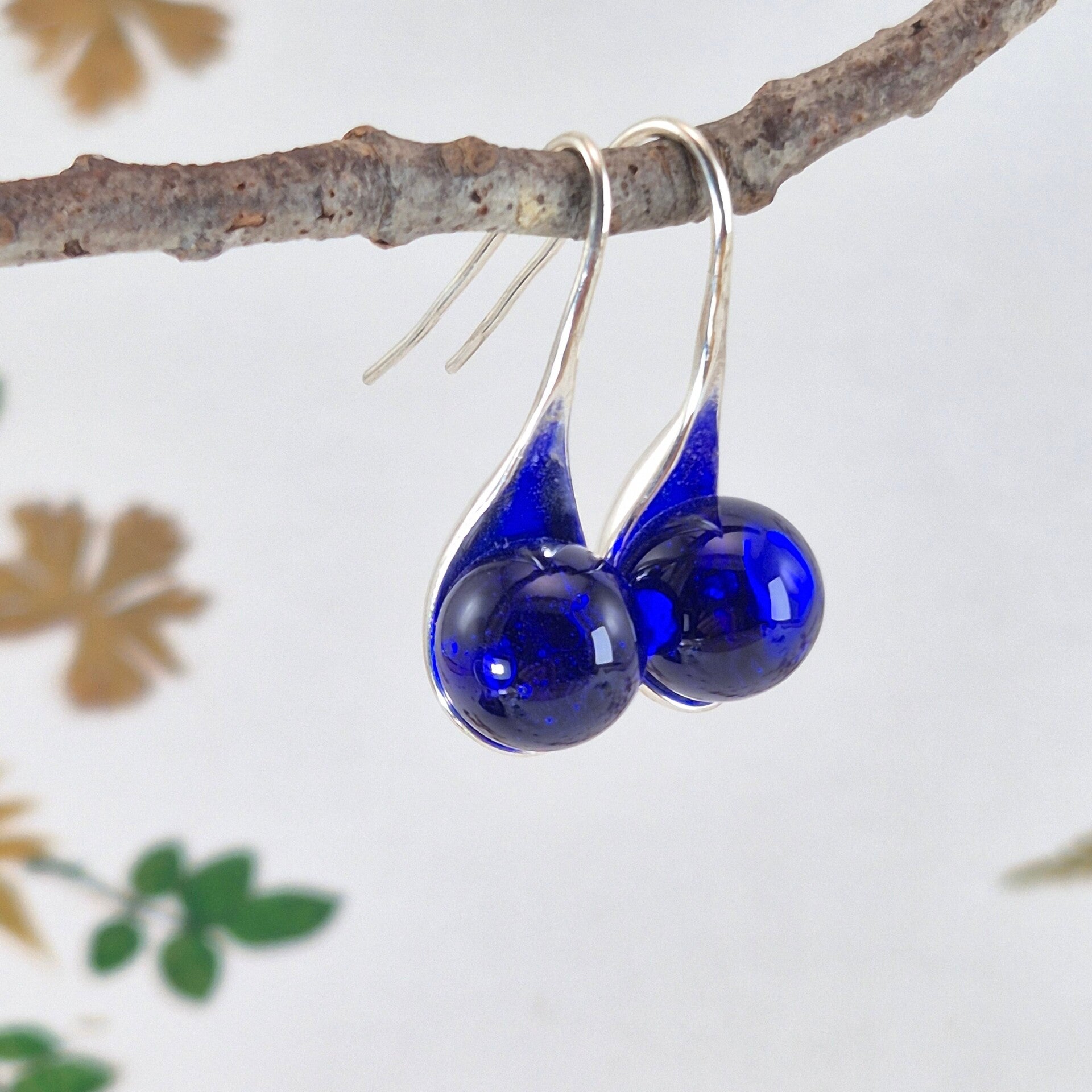 Verzilverde oorbellen met transparant blauwe glasbolletjes