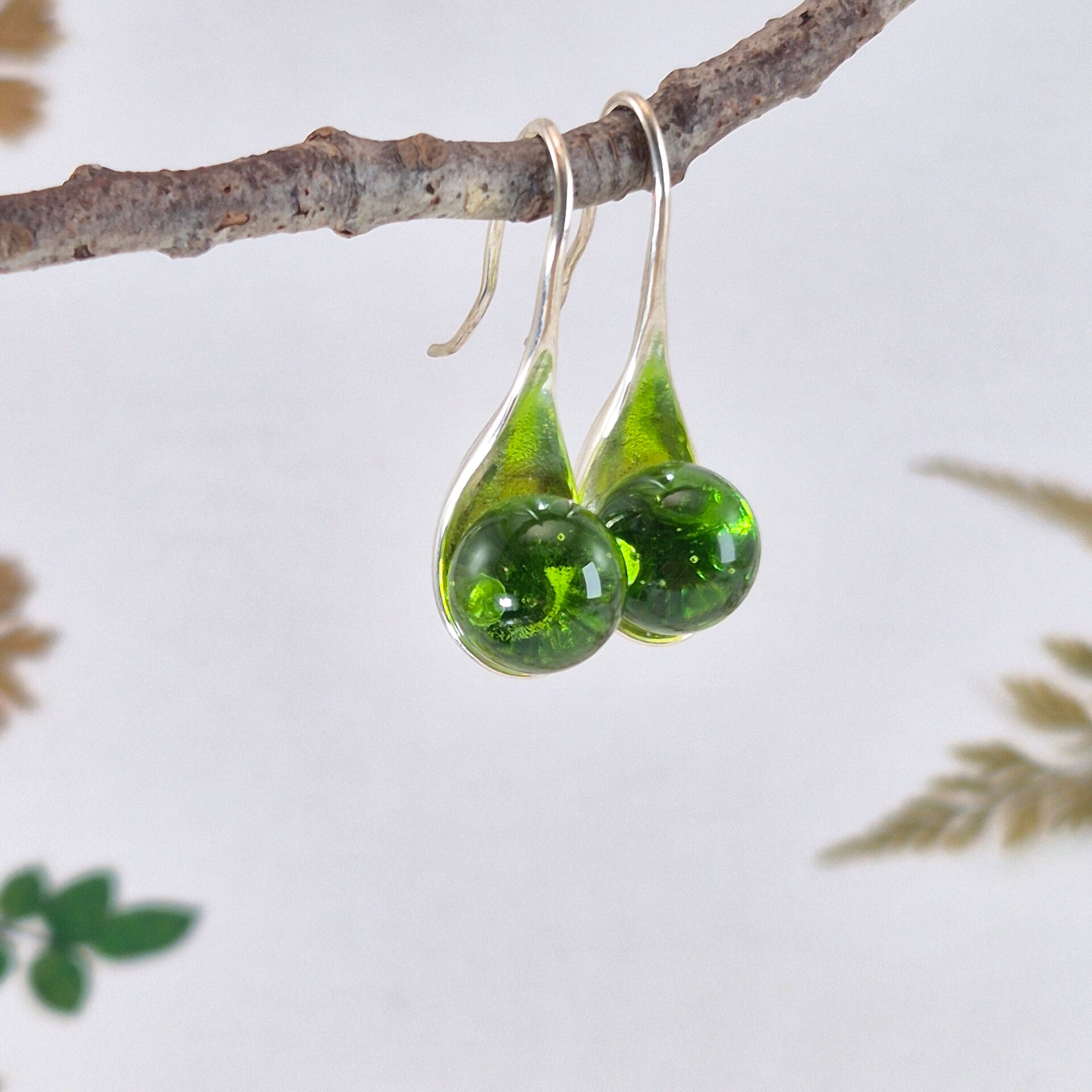 Verzilverde oorbellen met grasgroene glasbolletjes