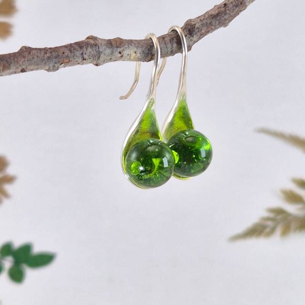Verzilverde oorbellen met grasgroene glasbolletjes