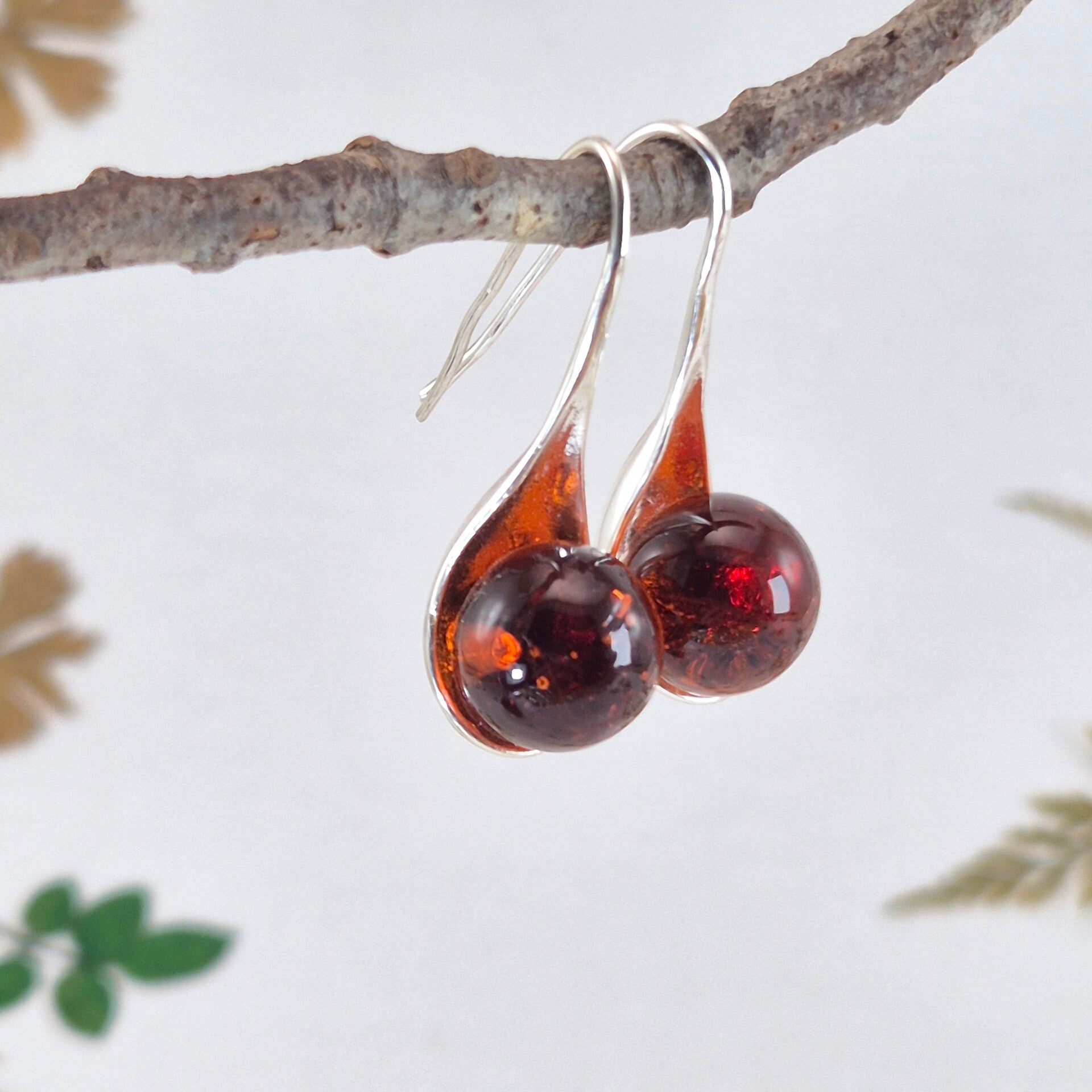 Verzilverde oorbellen met transparant amberkleurige glasbolletjes