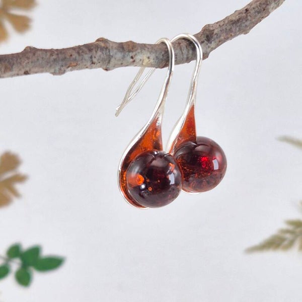 Verzilverde oorbellen met transparant amberkleurige glasbolletjes