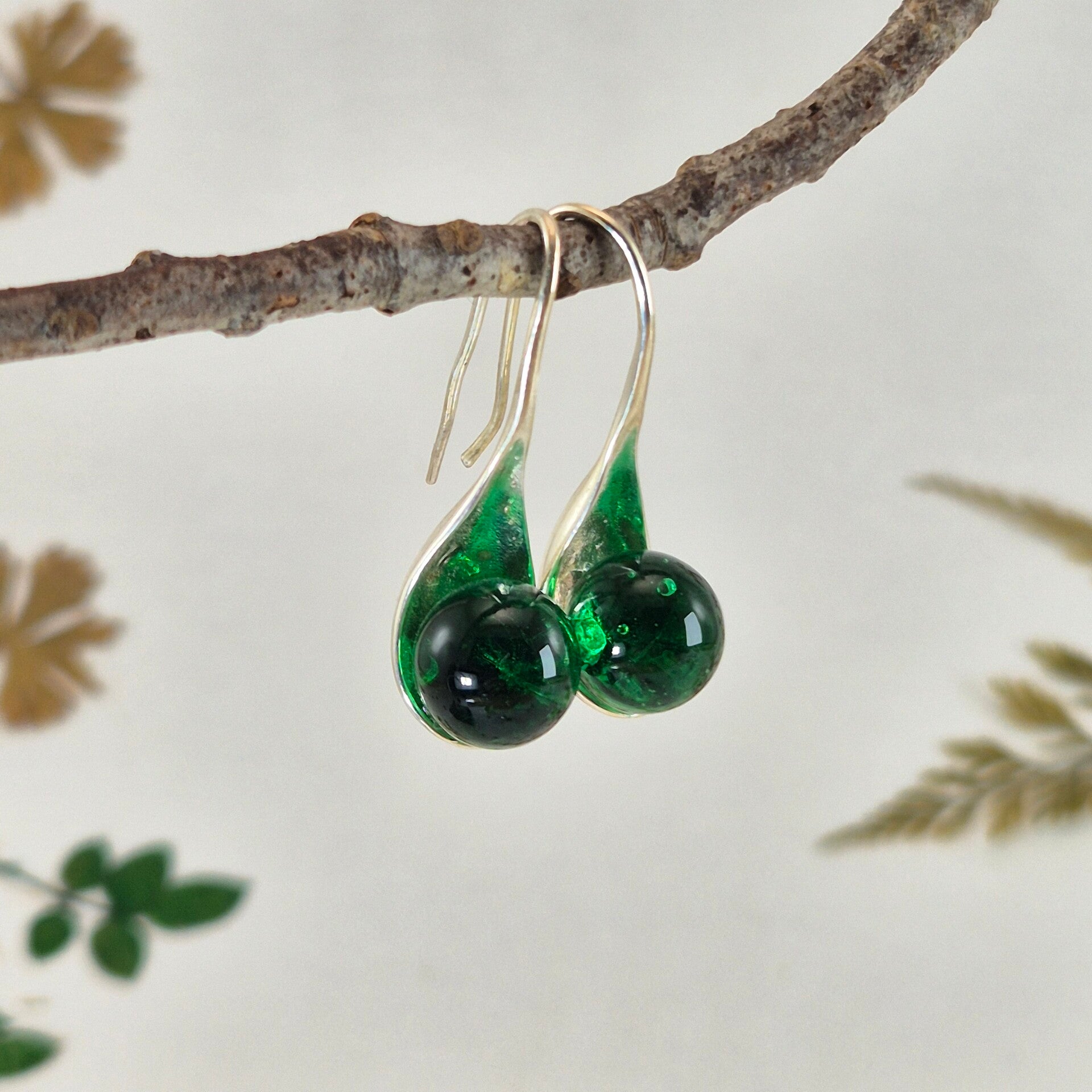 Verzilverde oorbellen met hardgroene glasbolletjes