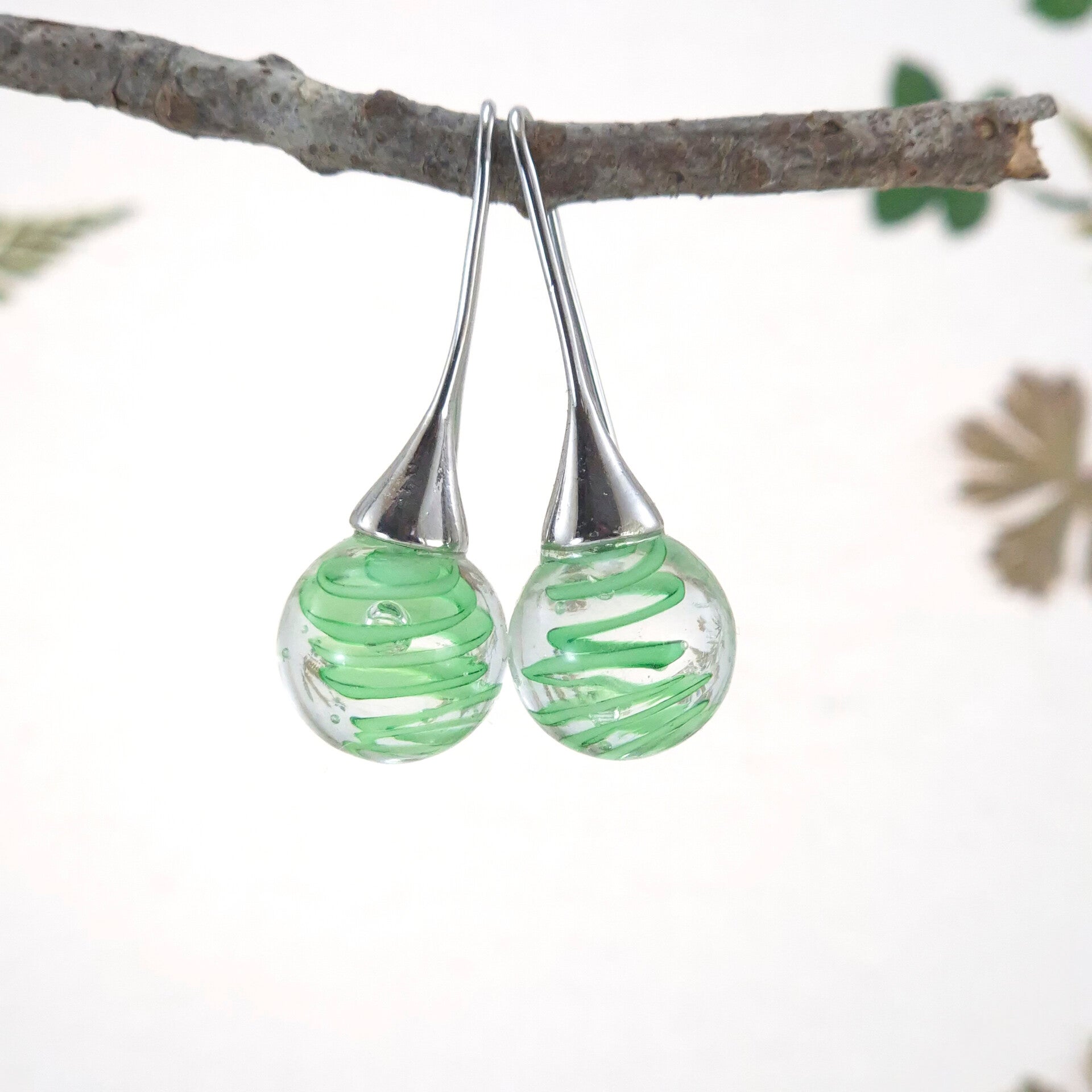 Glazen oorbellen met bolletjes van transparant glas met daarin een groene spiraal