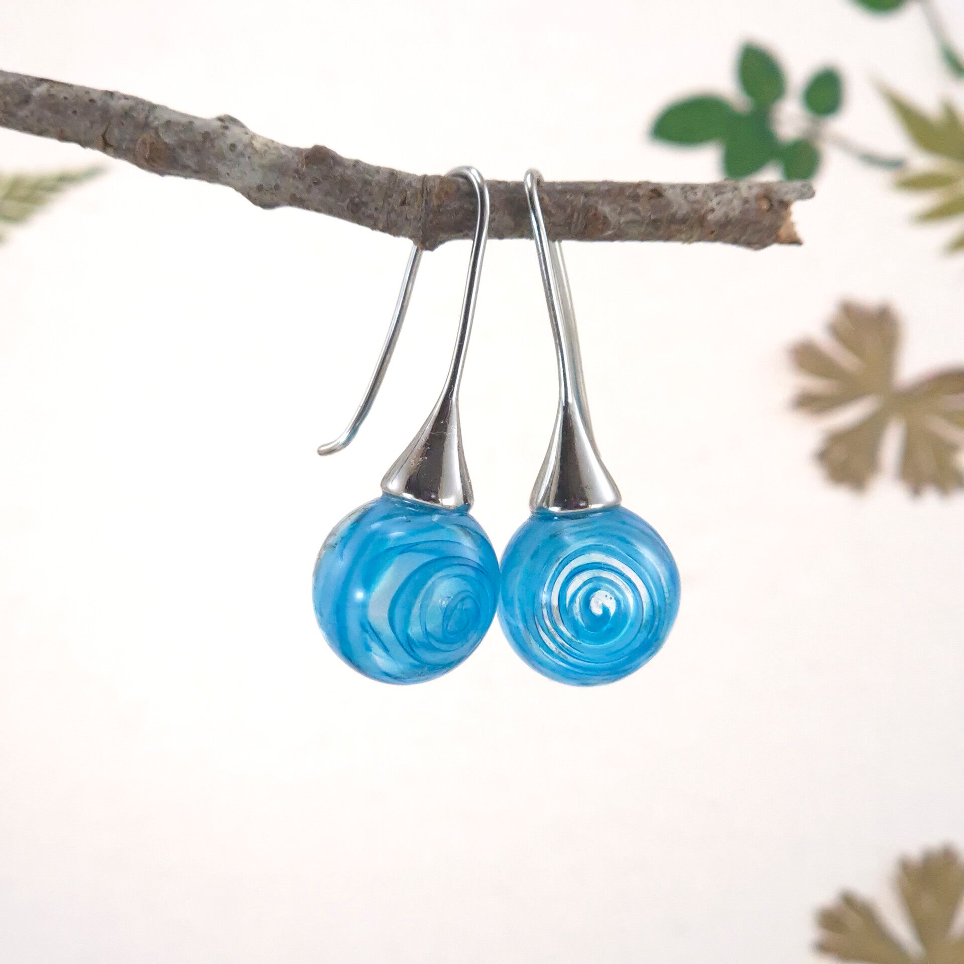 Glazen oorbellen met bolletjes van transparant glas met daarin een turquoise-blauwe spiraal - 2