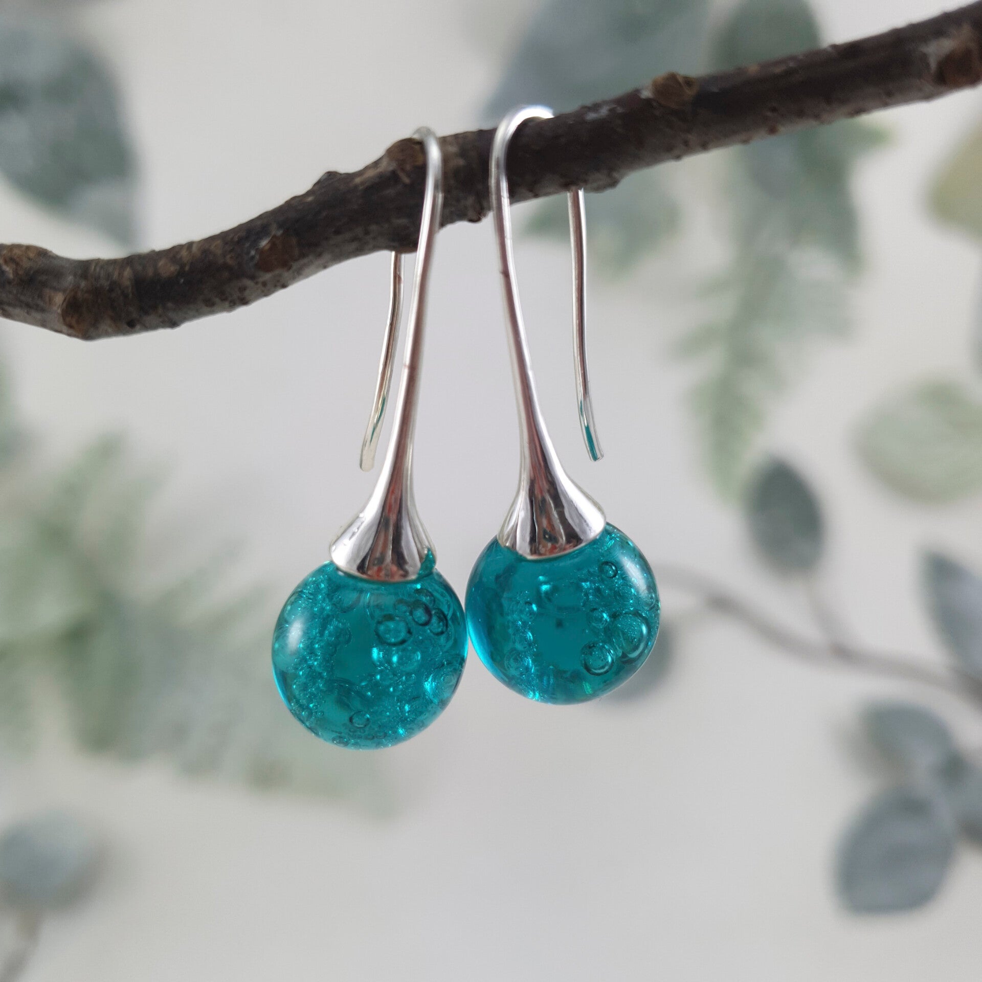Oorbellen met zeegroene glasbolletjes