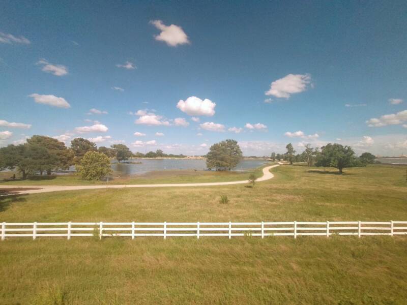 landscrape with lake and white fence seen from the Amtrak window