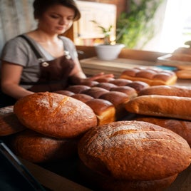 panadero-femenino-con-pan-horneado-en-la-pasteleria-standard-iis52s.jpg