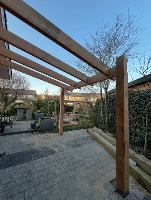 Overkapping in aanbouw tegen zijgevel huis