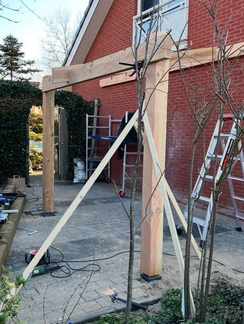 Overkapping in aanbouw tegen zijgevel huis